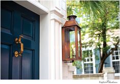 an old fashioned lantern hanging on the side of a house