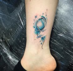 a tattoo on the foot of a person with a blue balloon and stars around it