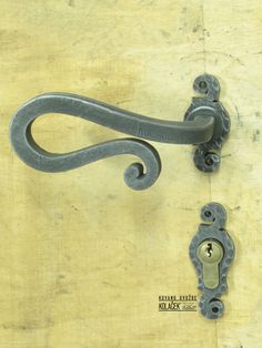 an old door handle and latch on a wooden surface