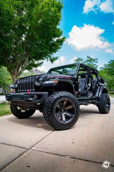 a black jeep parked in front of a tree