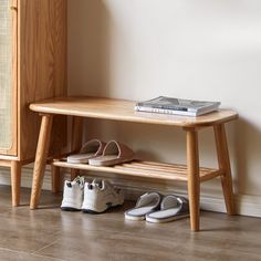 two pairs of shoes are sitting on a wooden bench next to a bookshelf