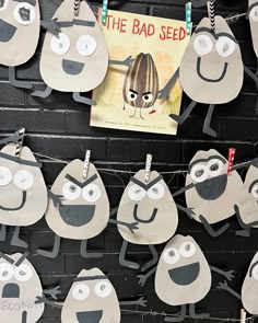 paper cut out of cartoon characters hanging on a brick wall with a book in the background