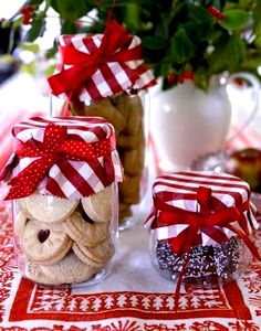 two jars filled with cookies sitting on top of a red and white tablecloth covered table