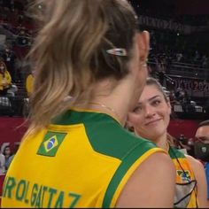 two women standing next to each other at a basketball game