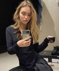 a woman is taking a selfie with her cell phone while sitting on the floor