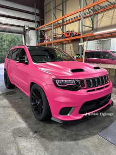 a pink jeep is parked in a garage