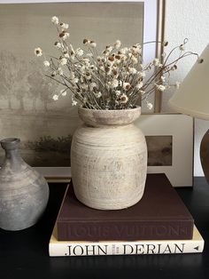 a vase filled with flowers sitting on top of two books