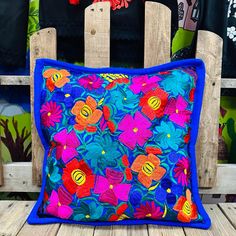 a colorful pillow sitting on top of a wooden chair