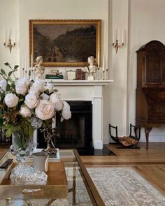 a living room filled with furniture and a fire place in front of a painting on the wall