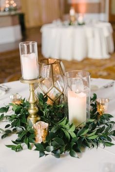 a table with candles and greenery on it