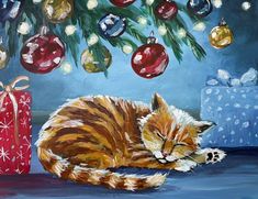 an orange and white cat laying next to a christmas tree