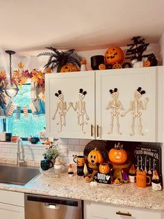 a kitchen decorated for halloween with skeletons and pumpkins