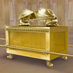 two golden statues sitting on top of a gold box