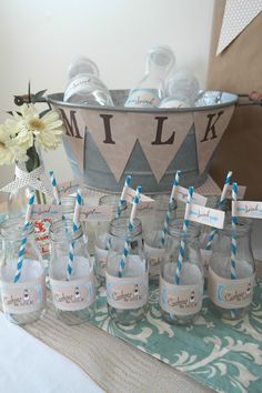 there are many bottles with blue and white striped straws in them on the table