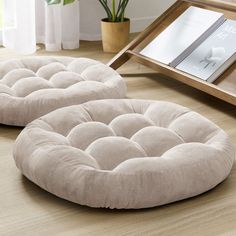 two round cushions sitting on top of a wooden floor