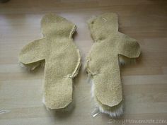 two teddy bears made out of felt sitting on a wooden floor next to each other