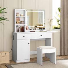 a white dressing table with a mirror and stool in front of it, next to a potted plant