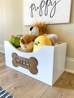 a toy box with stuffed animals in it and a sign on the wall behind it