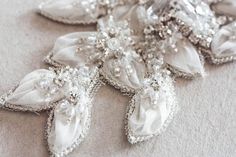 Nostalgic of precious jewelry, each MillieIcaro Sash is made from pearls, mounted swarovski crystals, and silk thread. Beautifully intricate, each sash emanates old Hollywood Glamor and vintage feel making it both luscious and trendy. A prefect bridal belt to add on a simple wedding dress to add shimmer. * Offwhite fabric work with silver beading and swarovski rhinestones* The beaded section is about 14.5 inch in length with a max width in the center about 4 inches. This tapers on either side to Elegant Embellished Sashes, Elegant Embellished Sashes For Party, Elegant Beaded Silver Sashes, Elegant Silver Beaded Sash, Elegant Silver Bridal Belt With Pearl Embroidery, Wedding Belts And Sashes, Flowers And Crystals, Hollywood Glamor, Fabric Work