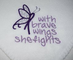 a white pillow with embroidered words and a purple butterfly on the front that says, with brave wings sheighghts