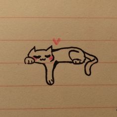 a drawing of a cat laying on top of a piece of lined paper with a heart