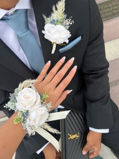 a man in a suit and tie with flowers on his lapel, holding a briefcase