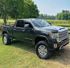 a black truck is parked in the grass