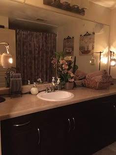 a bathroom with a sink, mirror and lights on the wall above it's counter