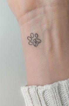 a small paw tattoo on the wrist