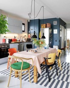 a dining room table with chairs and a potted plant