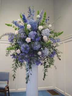 a white vase filled with blue and white flowers