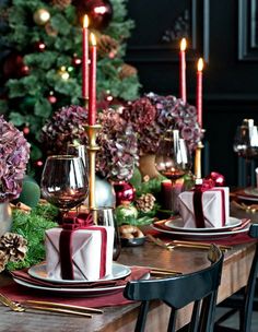 the table is set for christmas dinner with candles