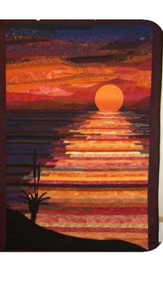 a quilted wall hanging with a sunset and cactus in the foreground, on a white background