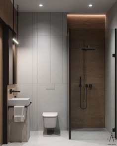 a bathroom with a toilet, sink and shower in it's center wall is lit by recessed lighting