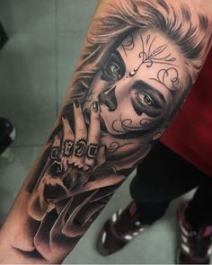 a woman's arm with a tattoo on it and a skull in the middle