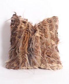 two decorative pillows made out of fur on a white background