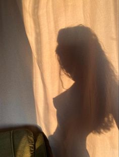 a woman with long hair standing in front of a curtain