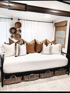 a bed with lots of pillows on top of it