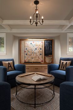 a living room with two blue chairs and a coffee table in front of a window