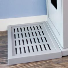 a white microwave oven sitting on top of a wooden floor next to a blue wall