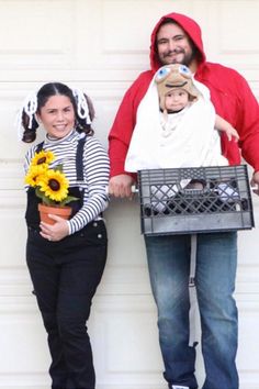 a man and woman dressed up in costumes standing next to a garage door with sunflowers