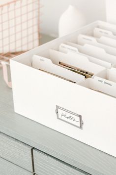 an open file cabinet filled with files and folders on top of a wooden table