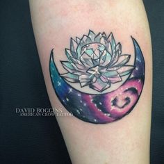 a lotus and crescent moon tattoo on the right arm, with stars in the background