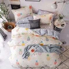 a bed with pineapples on it in a room next to a table and potted plants