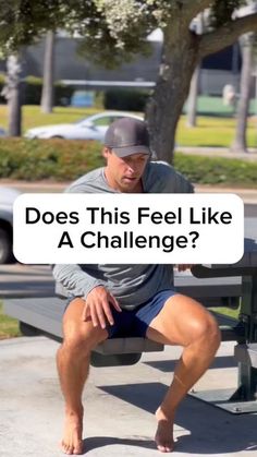 a man sitting on top of a bench next to a sign that says does this feel like a challenge?