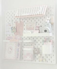 there is a keyboard and other items on the shelf in this white room with polka dot wallpaper