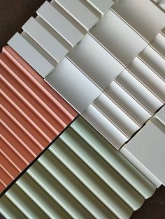 several different types of metal roofing tiles on a wooden surface with white, red and green tints