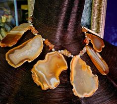 Here's a piece of my very early work that I had forgotten I even had. Seven earth tone agate slabs are displayed in a gemstone statement bib with smaller polished agate nuggets and shiny silver tone balls. This is very lightweight and adjusts from 16-18" and I can add more links if requested. Has a sterling silver hook and a 2" extender chain. A versatile unisex piece that works with casual to business attire. From the Atelier of Kat Kouture. Rocker Chic Accessories, Unique Pendant Necklace, Statement Collar Necklace, Bib Collar, Statement Bib Necklace, Mermaid Necklace, Agate Slice, Statement Pendant, Black Feathers