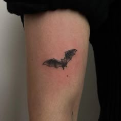 a small bat tattoo on the leg