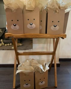 some brown paper bags are sitting on a wooden stand with two bears painted on them